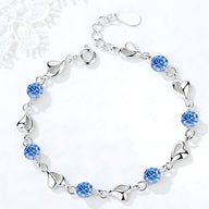 Bracelet femme en argent avec maille en cœur et pierres bleues scintillantes.