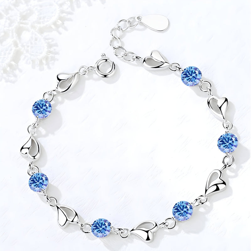 Bracelet femme en argent avec maille en cœur et pierres bleues scintillantes.