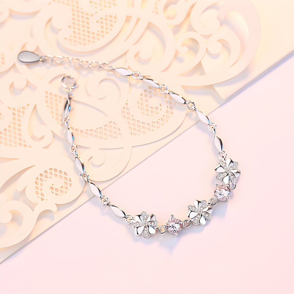 Bracelet en argent avec chaîne fine et pendentifs trèfles à quatre feuilles délicats.