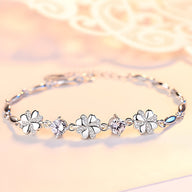 Bracelet en argent avec motifs trèfles à quatre feuilles et zircones scintillantes sur chaîne fine.