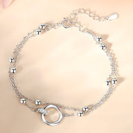 Bracelet femme en argent sterling avec double chaîne fine et anneau central rond poli.