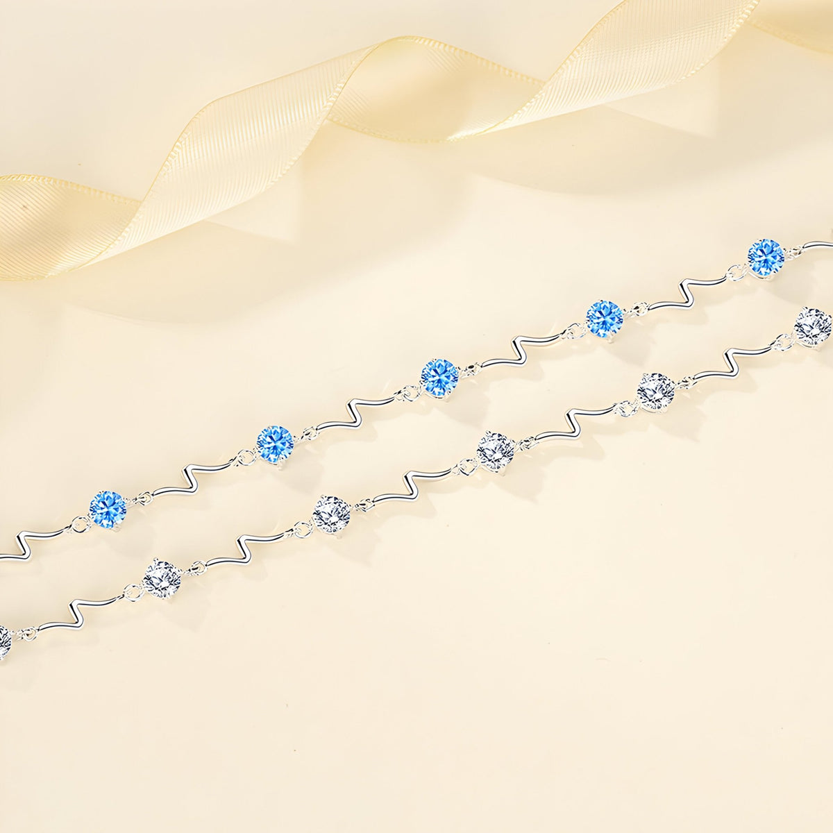 Bracelet fin en argent sterling avec perles bleues et argentées, design ondulé élégant.