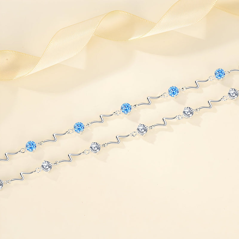 Bracelet fin en argent sterling avec perles bleues et argentées, design ondulé élégant.