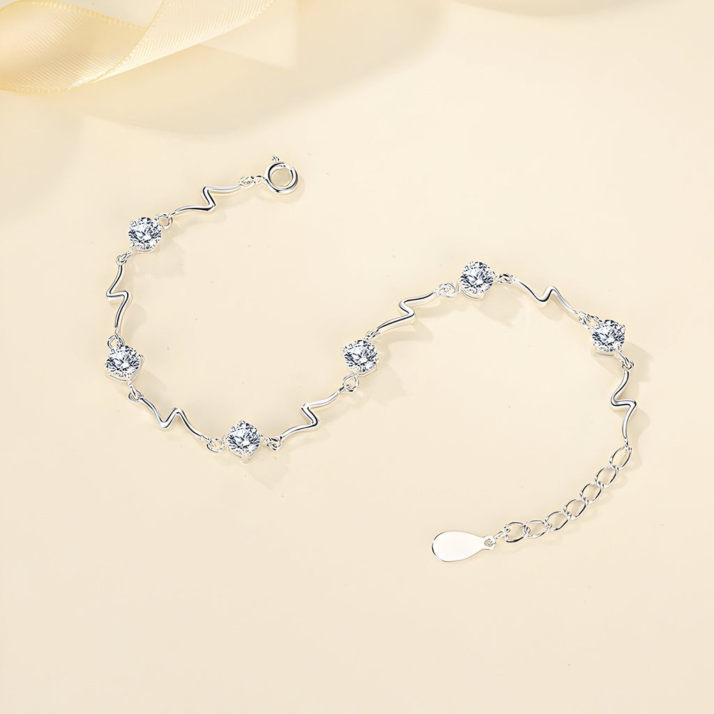 Bracelet en argent sterling avec motifs ondulés et cristaux ronds, fermoir ajustable.