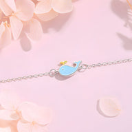 Bracelet fin en argent sterling avec pendentif baleine bleue aux détails dorés sur chaîne délicate.