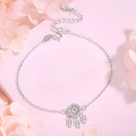 Bracelet en argent sterling fin avec pendentif attrape-rêves et plumes délicates.