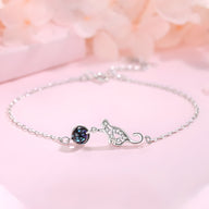 Bracelet fin en argent sterling avec pendentif chat délicat et petit cristal noir.