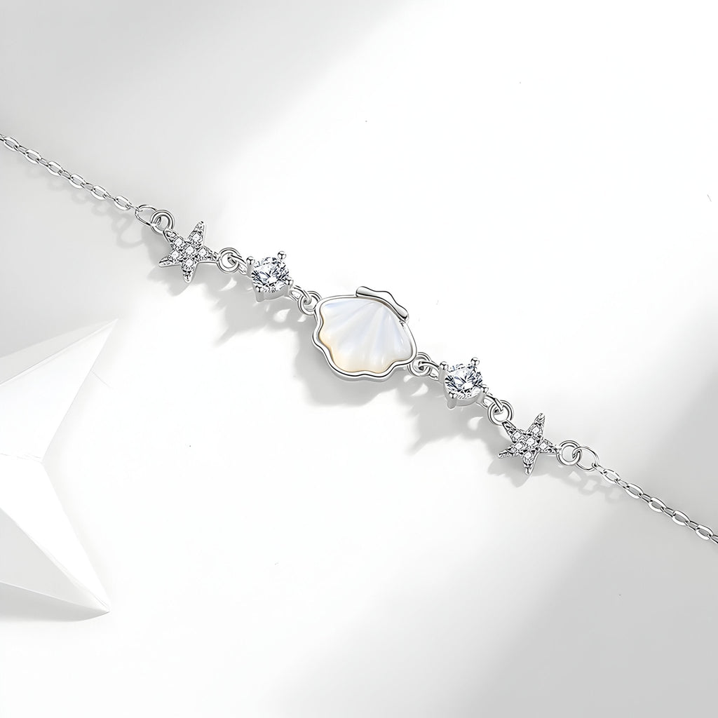 Bracelet en argent sterling avec pendentifs coquillage nacré et étoiles de mer délicates.