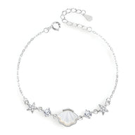 Bracelet en argent sterling pour femme avec charms coquillage et étoiles de mer délicates.