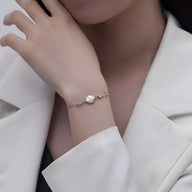 Bracelet en argent sterling avec charme coquillage et étoiles de mer fines, style délicat pour femme.