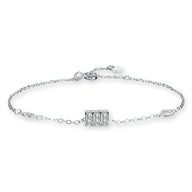 Bracelet fin en argent sterling avec charm cylindrique à détails texturés, fermoir ajustable.
