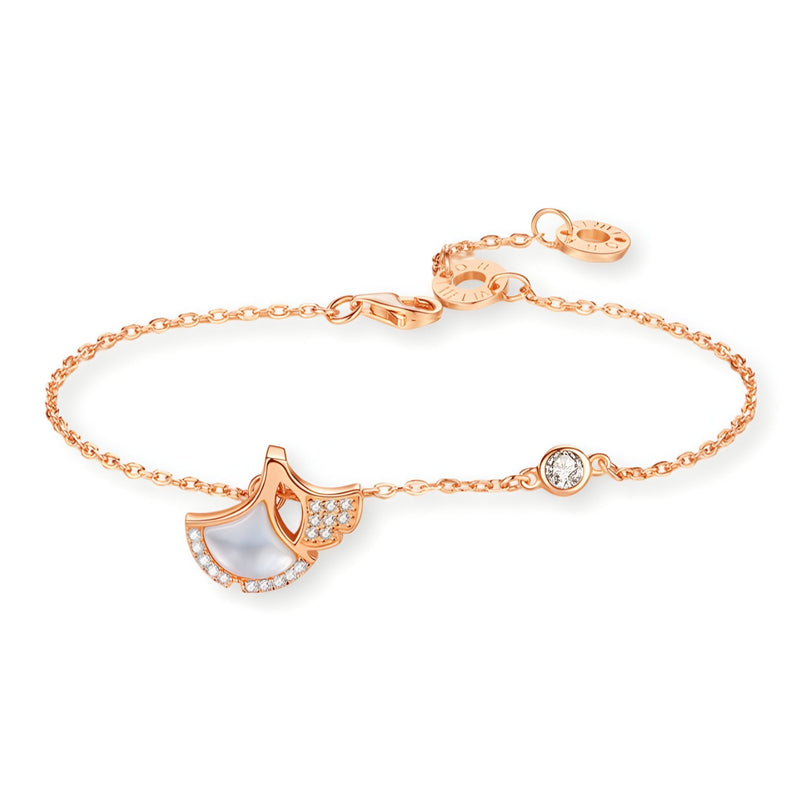 Bracelet fin en or rosé avec pendentif feuille de ginkgo en nacre et petits cristaux blancs.