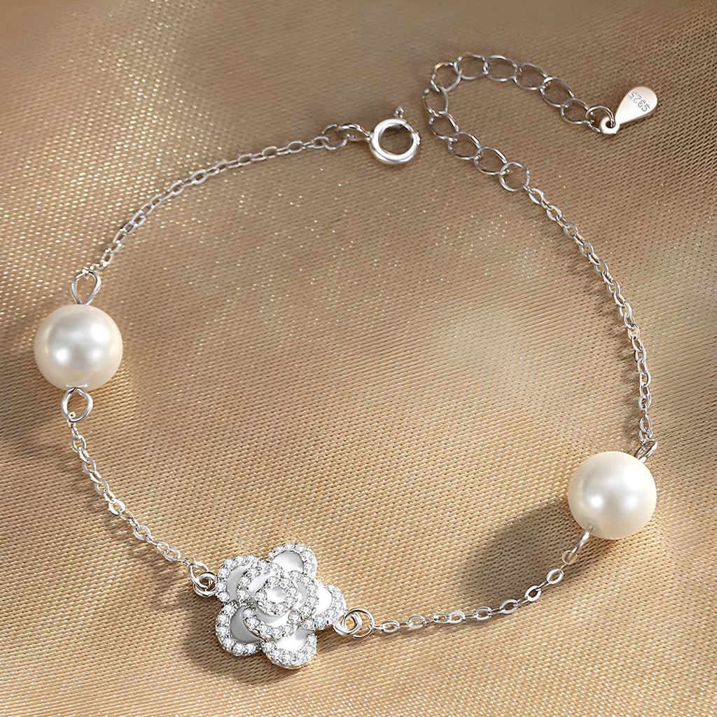 Bracelet en argent sterling avec charm floral orné de cristaux et perles blanches élégantes.