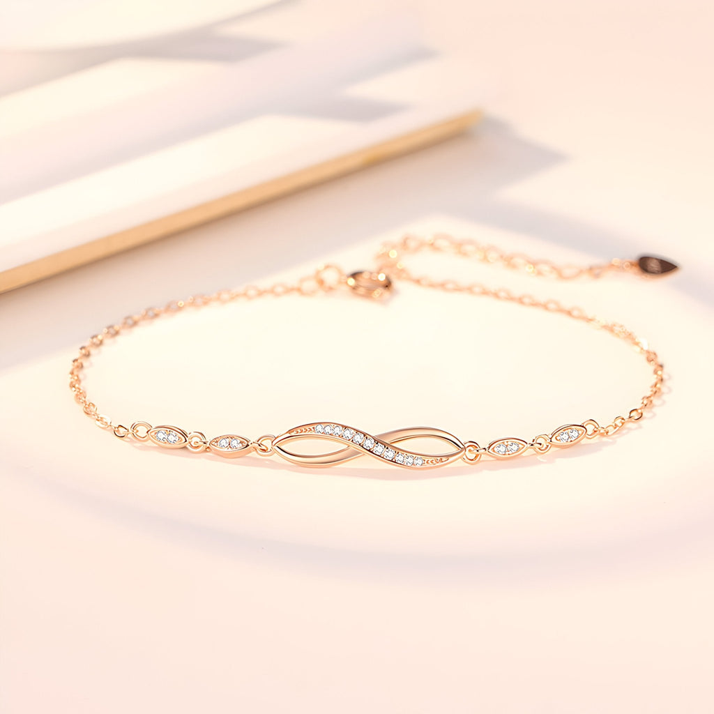 Bracelet or fin avec charm infini orné de pierres scintillantes sur chaîne délicate.