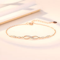 Bracelet or fin avec charm infini orné de pierres scintillantes sur chaîne délicate.