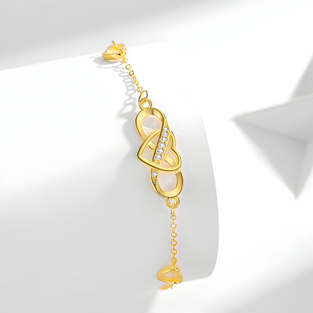 Bracelet en or avec charm infini et cœur délicat, finition brillante et chaîne fine ajustable.