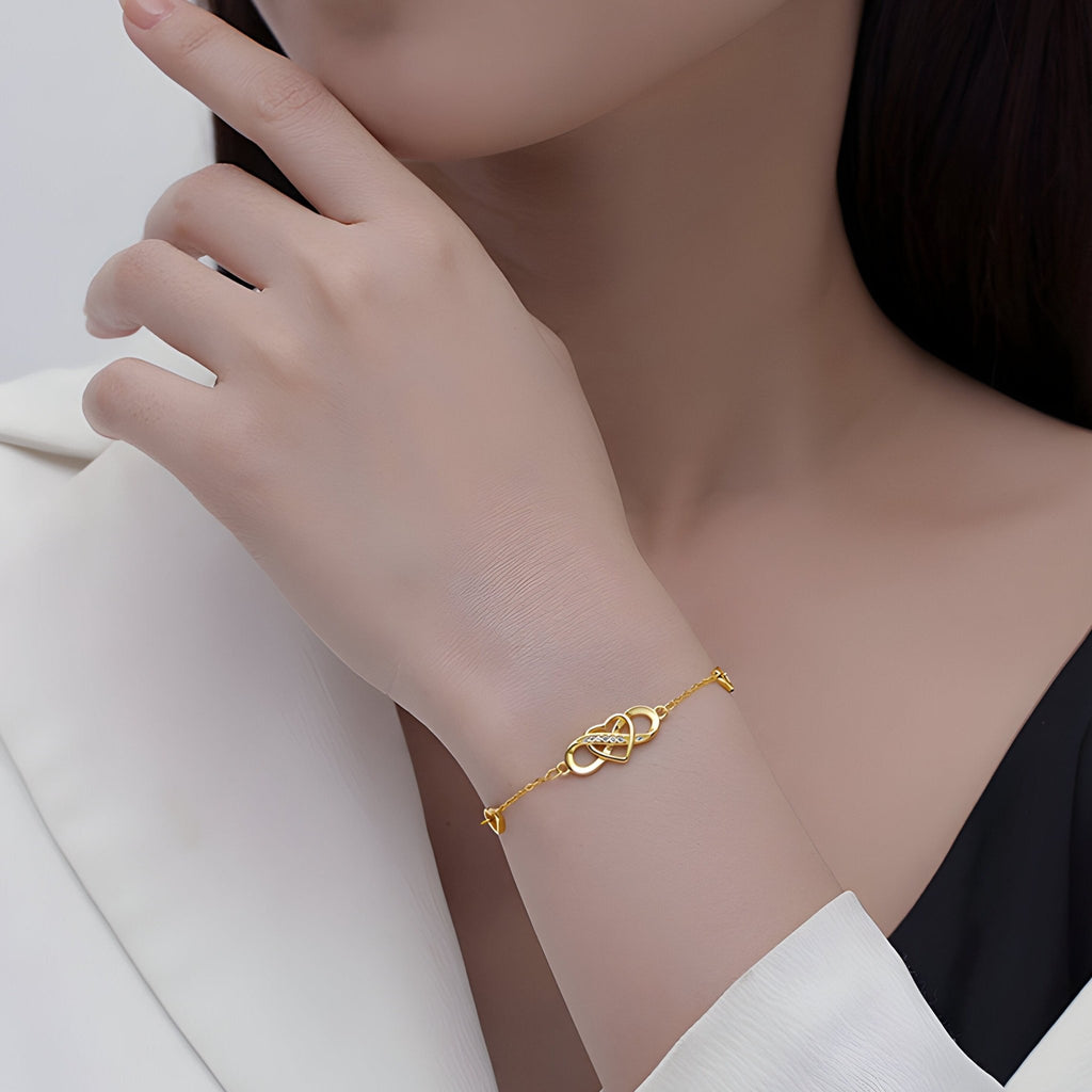 Bracelet en argent sterling avec charm infini et coeur, design délicat et élégant, porté au poignet féminin.
