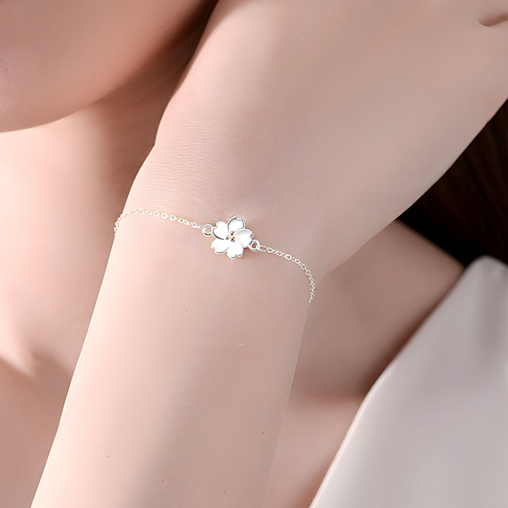 Bracelet fin en argent sterling avec charm marguerite délicate sur poignet féminin.