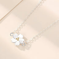 Bracelet en argent sterling avec pendentif marguerite blanche aux détails dorés élégants.