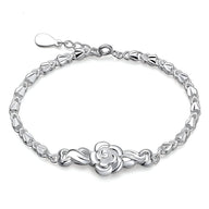 Bracelet argent sterling pour femme avec charme floral délicat au centre, fermeture ajustable.