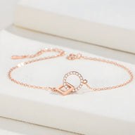 Bracelet fin en argent rosé avec charms géométriques circulaire et carré ajouré.