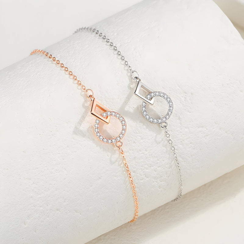 Bracelet fin en argent sterling avec charms géométriques cerclés de petites pierres, disponible en argent et or rosé.
