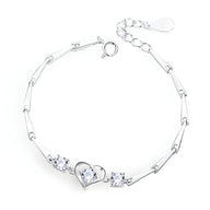 Bracelet en argent sterling avec chaîne fine et cœur central orné de petites pierres brillantes.