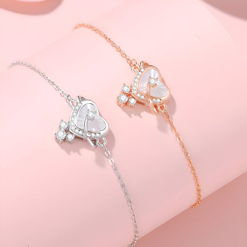 Bracelet fin en argent sterling avec pendentif cœur orné de pierres, style délicat.