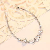 Bracelet en argent sterling avec deux cœurs difformes et chaîne fine pour femme.