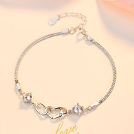 Bracelet argent sterling fin avec deux cœurs difformes et petits strass brillants.