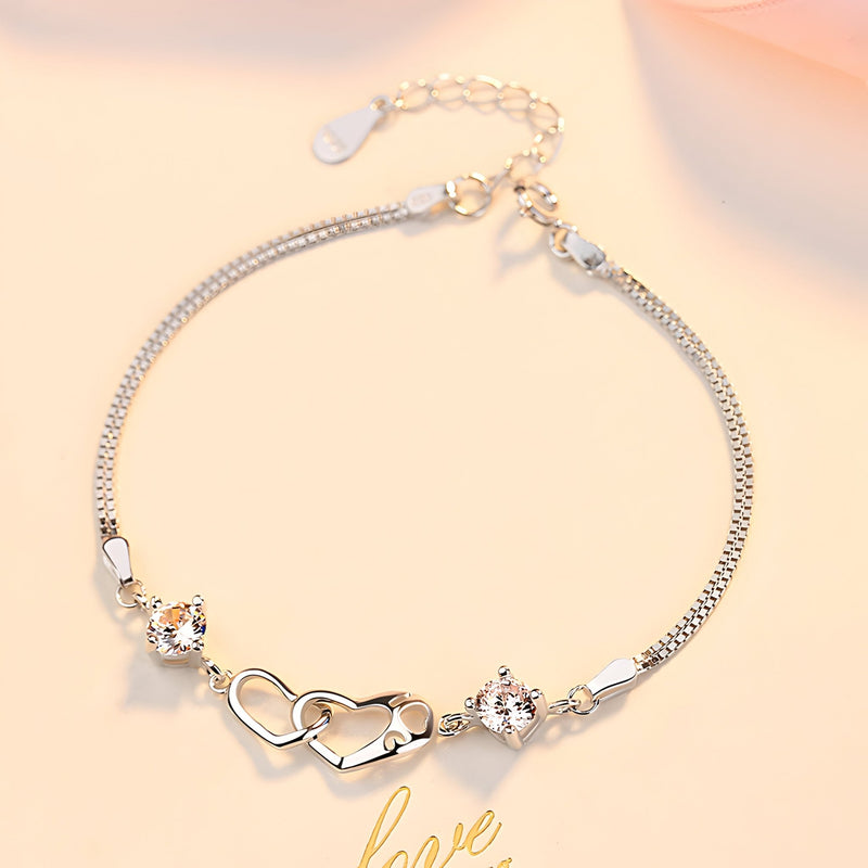 Bracelet argent sterling fin avec deux cœurs difformes et petits strass brillants.