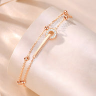 Bracelet en argent rose double chaîne avec barre centrale ornée de petits cristaux blancs.