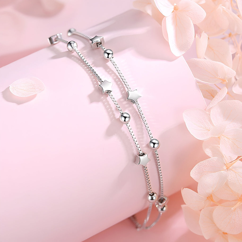 Bracelet fin en argent sterling avec petites étoiles et perles brillantes, design élégant pour femme.
