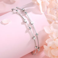 Bracelet fin en argent sterling avec petites étoiles et perles brillantes, design élégant pour femme.