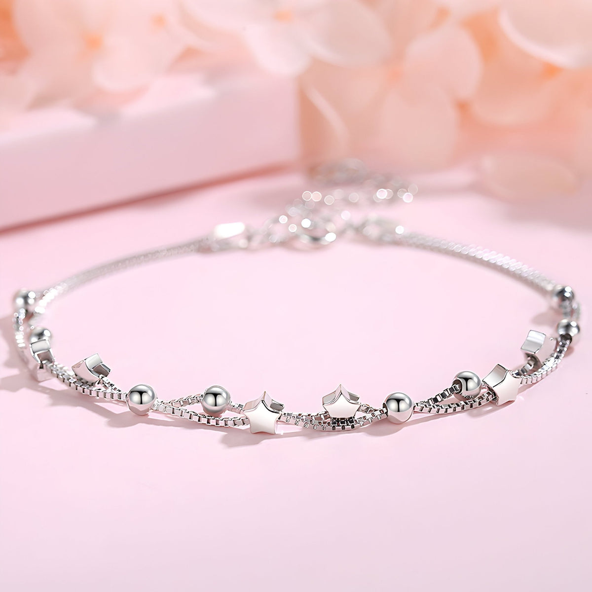 Bracelet fin en argent sterling avec petits motifs étoilés et billes, élégance délicate.