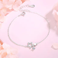 Bracelet fin en argent sterling avec double pendentif étoiles et chaîne délicate.