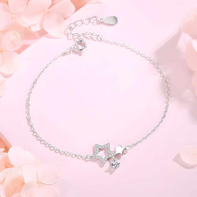 Bracelet fin en argent sterling avec double pendentif étoiles et chaîne délicate.