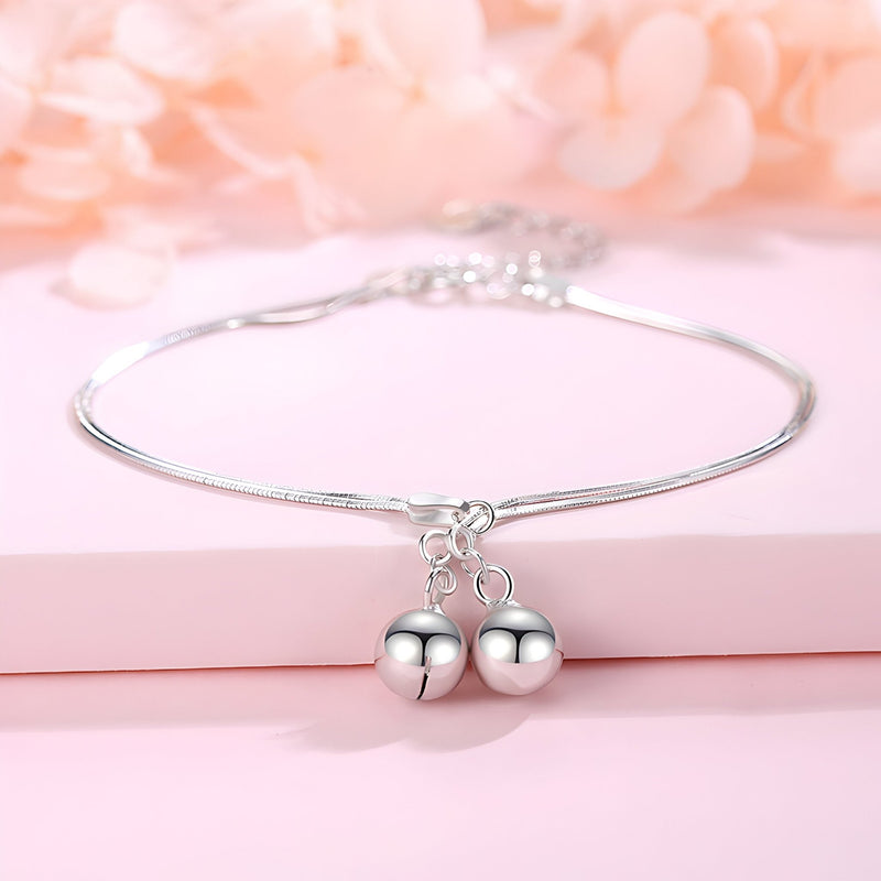 Bracelet fin en argent sterling avec deux perles rondes suspendues, style élégant et minimaliste.