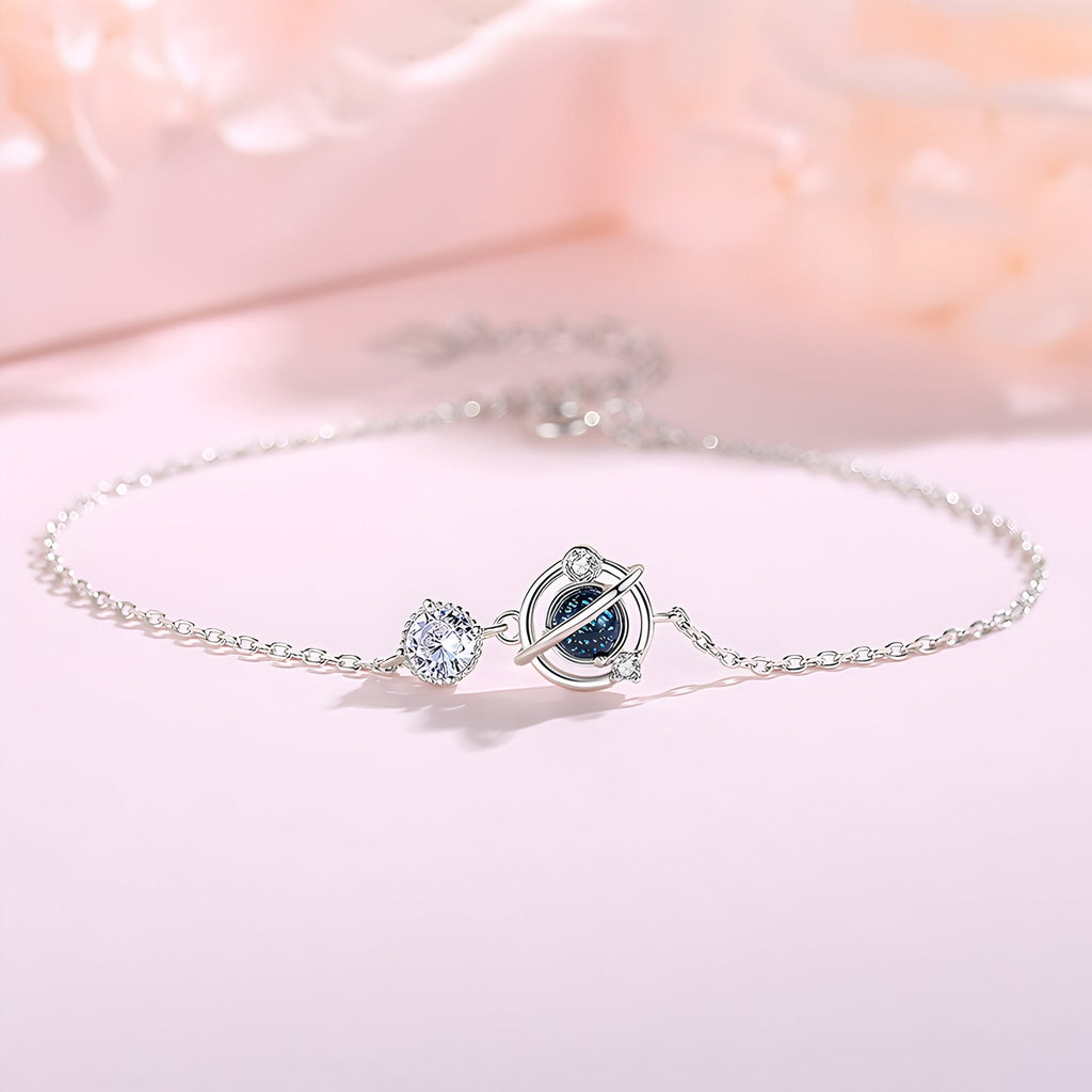 Bracelet en argent avec pendentif planète et étoile scintillante, design délicat et fin.