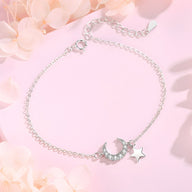 Bracelet en argent sterling fin avec pendentifs lune ciselée et étoile polie sur chaîne délicate.
