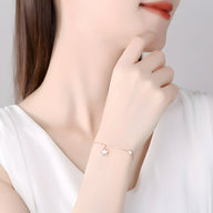 Bracelet fin en argent sterling avec pendentifs étoile et inscription "Love" portée au poignet féminin.