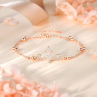 Bracelet fin en argent rosé avec étoile ornée de petites pierres brillantes.