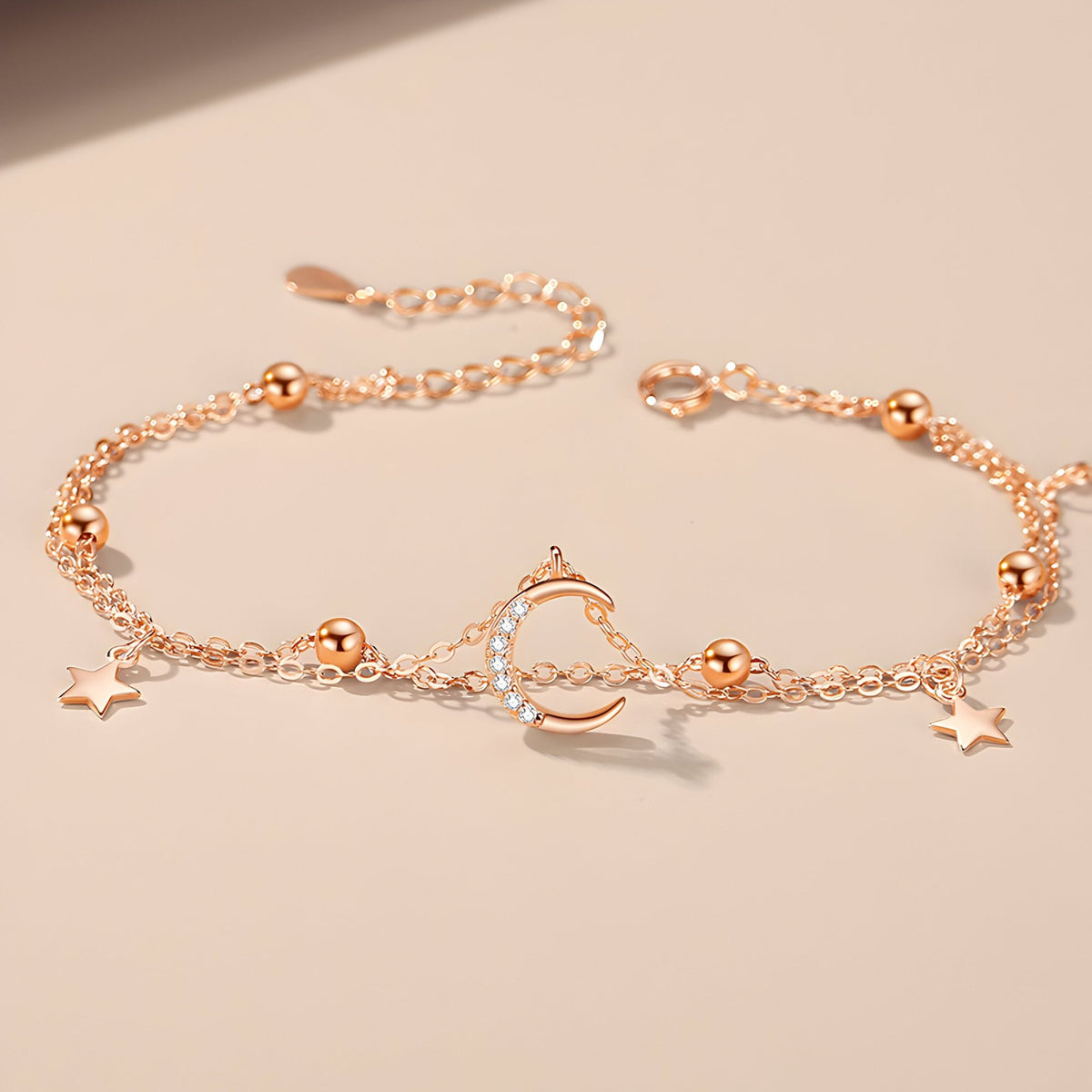 Bracelet en or rosé avec lune creuse et étoiles scintillantes en argent sterling.