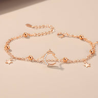 Bracelet en or rosé avec lune creuse et étoiles scintillantes en argent sterling.
