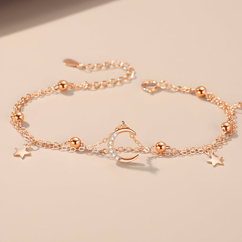Bracelet en or rosé avec lune creuse et étoiles scintillantes en argent sterling.