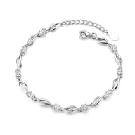 Bracelet femme en argent sterling avec maillons ondulés et détails floraux délicats.