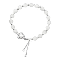 Bracelet argent sterling avec perles rondes blanches de jade et fermoir réglable en chaîne.