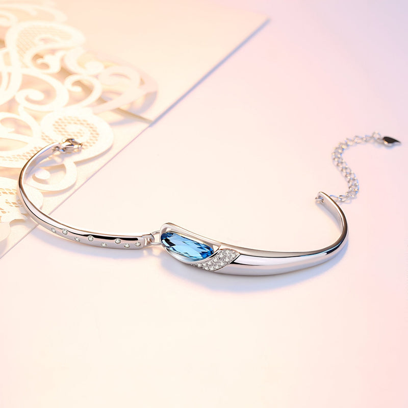 Bracelet en argent sterling fin avec pierre bleue ovale scintillante et détails élégants.