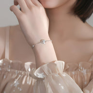 Bracelet en argent sterling fin avec oxyde de zirconium central rond porté au poignet.