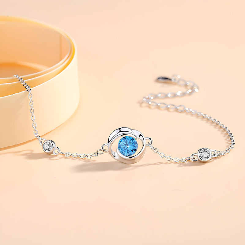 Bracelet en argent sterling avec zirconium bleu central et petits zirconiums clairs sur chaîne fine.